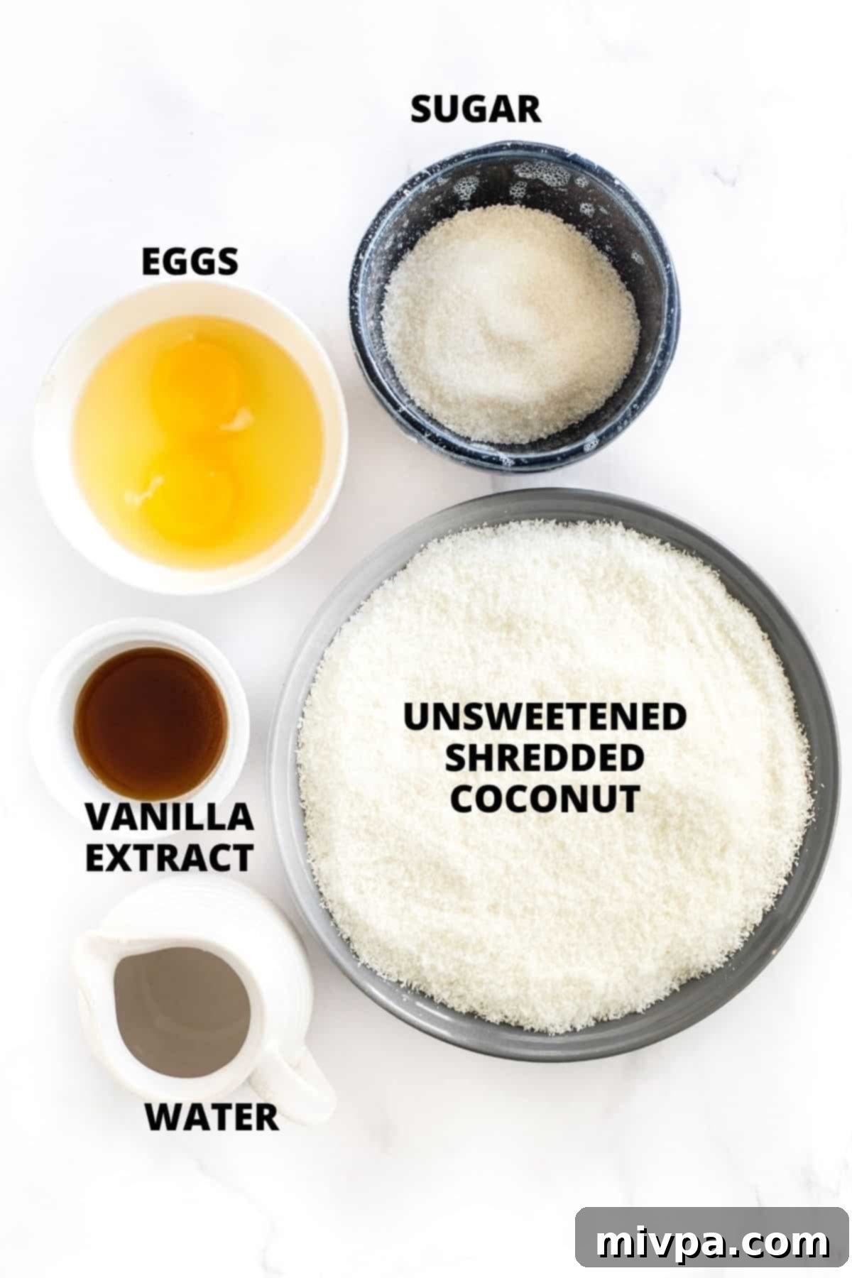Easy Gluten-Free Coconut Macaroons Recipe (Dairy-Free) - Ingredients Layout Clearly labeled ingredients for gluten-free coconut macaroons, neatly arranged on a pristine marble board, ready for baking.