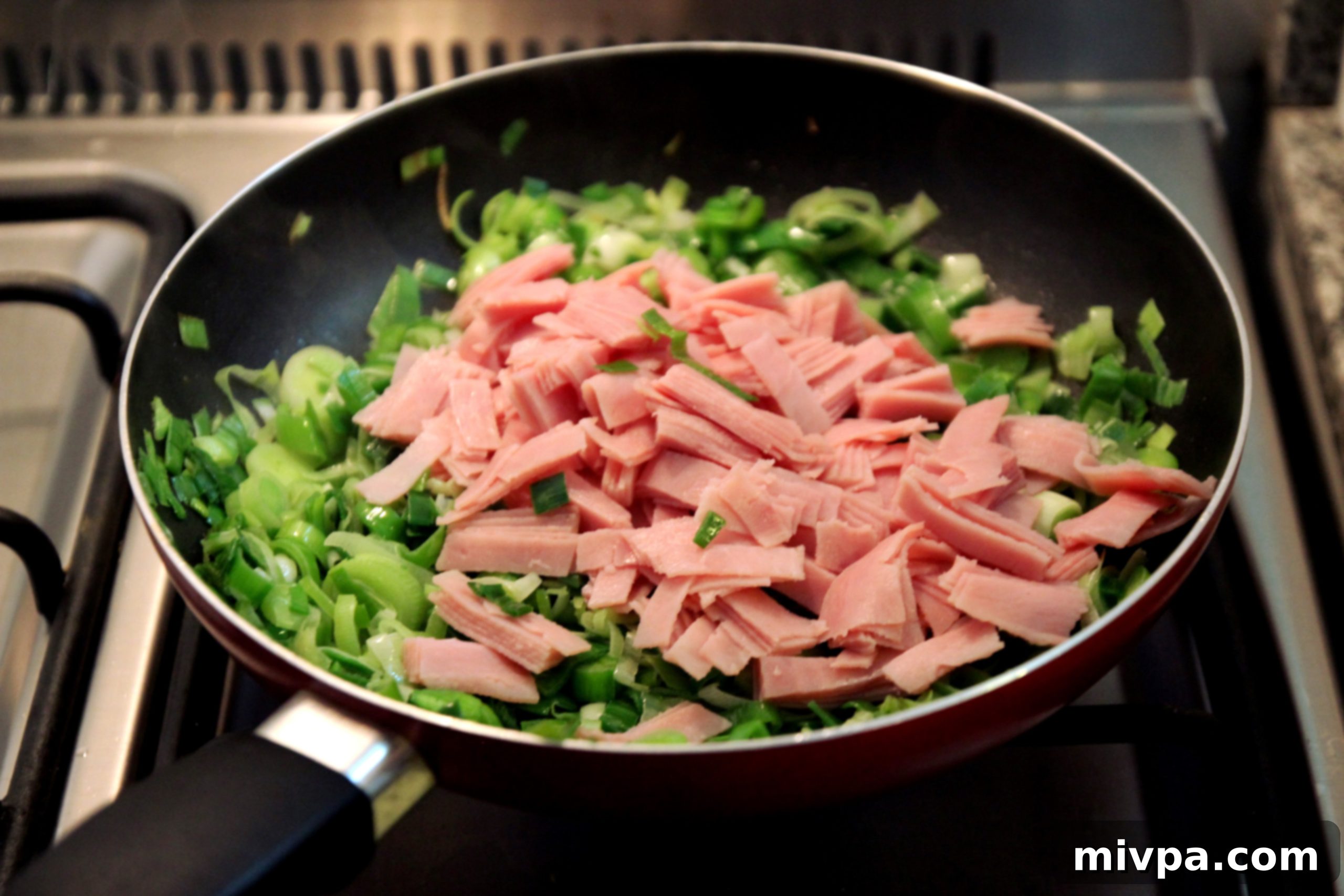 Mixing cooked leeks and ham
