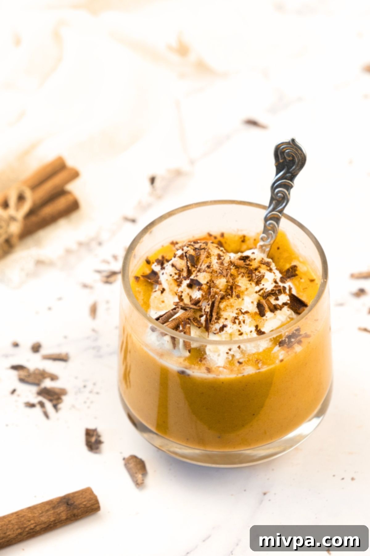 Pumpkin Pie Pudding A glass of pumpkin pie pudding topped with a dollop of cream and a sprinkle of cinnamon.