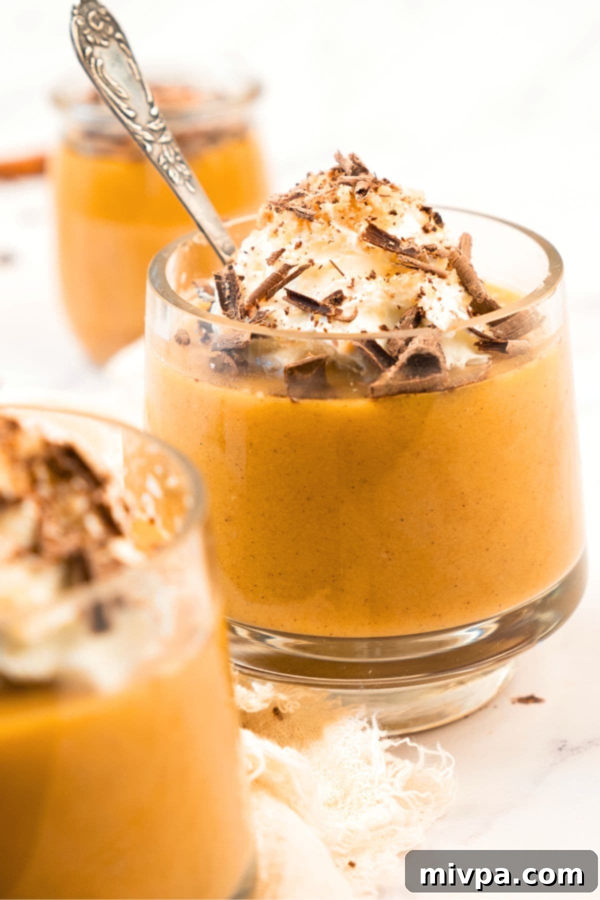 Gluten-Free Dairy-Free Pumpkin Pudding Up close view of glasses of gluten-free dairy-free pumpkin pudding, garnished with toppings.