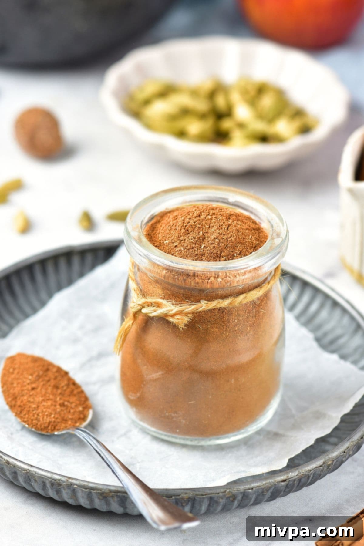 Homemade Apple Pie Spice Blend (Gluten-Free, Vegan) A beautiful jar of homemade apple pie spice blend sitting on a rustic parchment-lined tray, ready to be used.