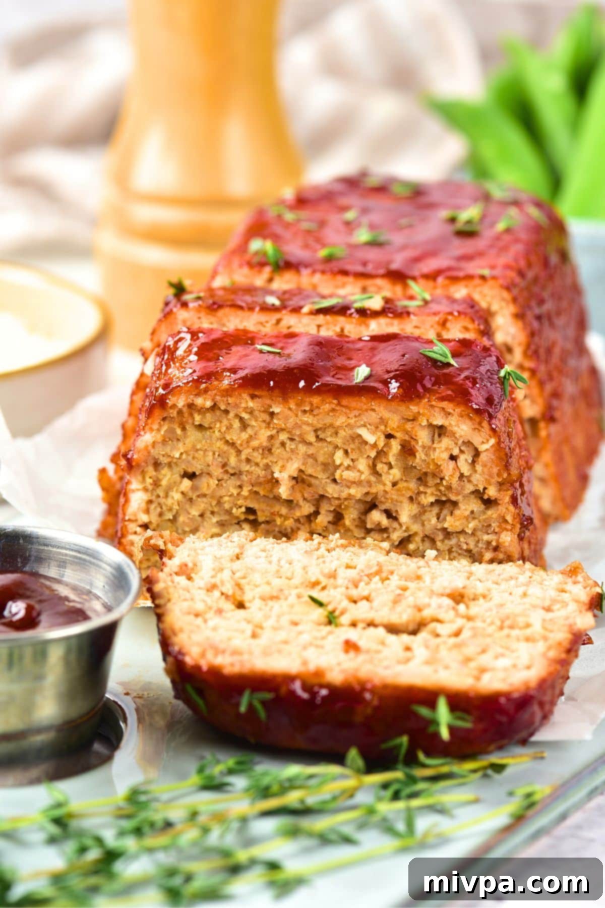 Easy Chicken Meatloaf (Gluten-Free, Dairy-Free) Sliced chicken meatloaf with fresh thyme.
