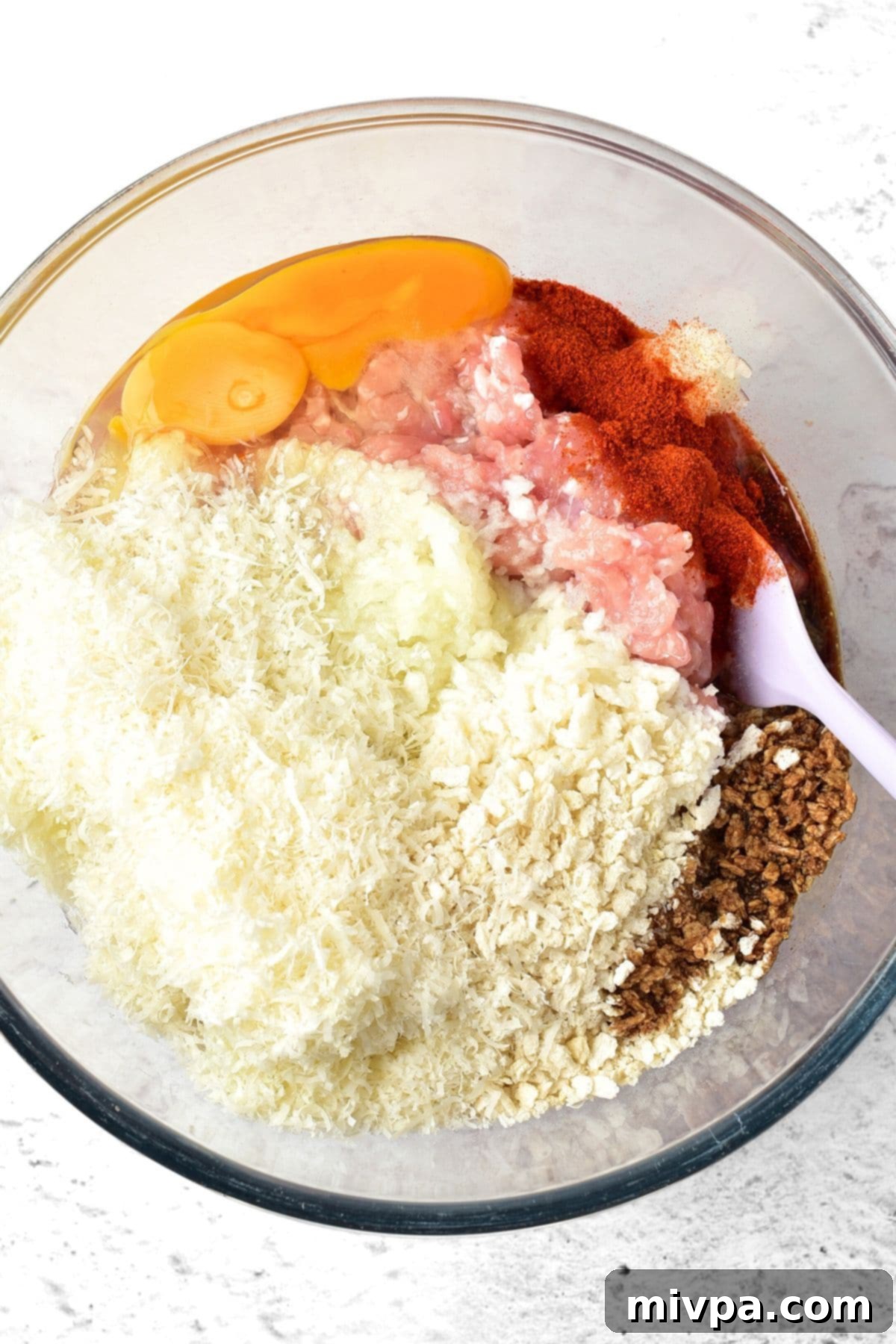 How to Make Chicken Meatloaf (Gluten-Free, Dairy-Free) Parmesan cheese, panko breadcrumbs, eggs, ground chicken and spices in bowl.