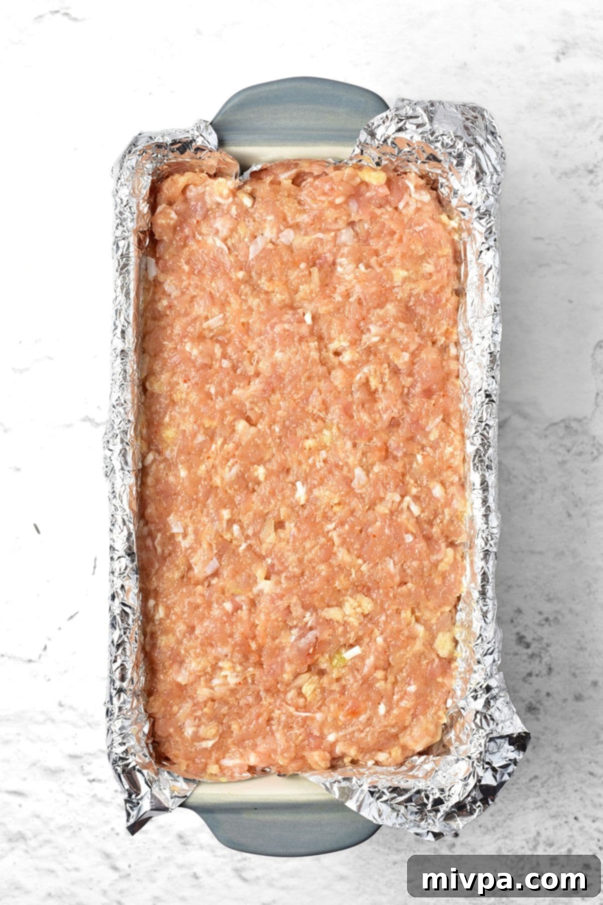 Gluten-Free Chicken Meatloaf Recipe Ground chicken mixture in foil-lined loaf pan