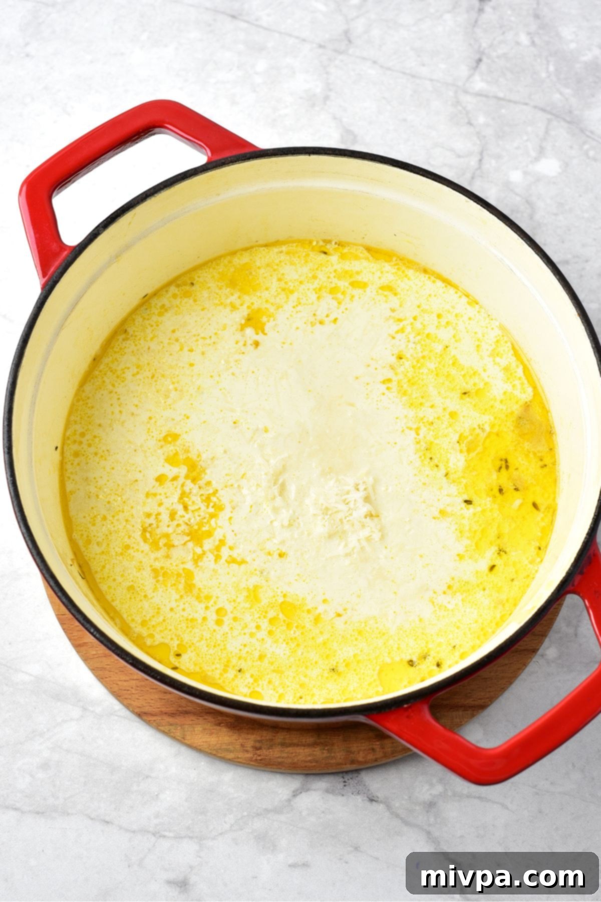 Creamy Texture in Chicken Gnocchi Soup Recipe A pot of creamy, light yellow soup after dairy-free heavy cream and shredded dairy-free Parmesan cheese have been stirred in, creating a rich texture.