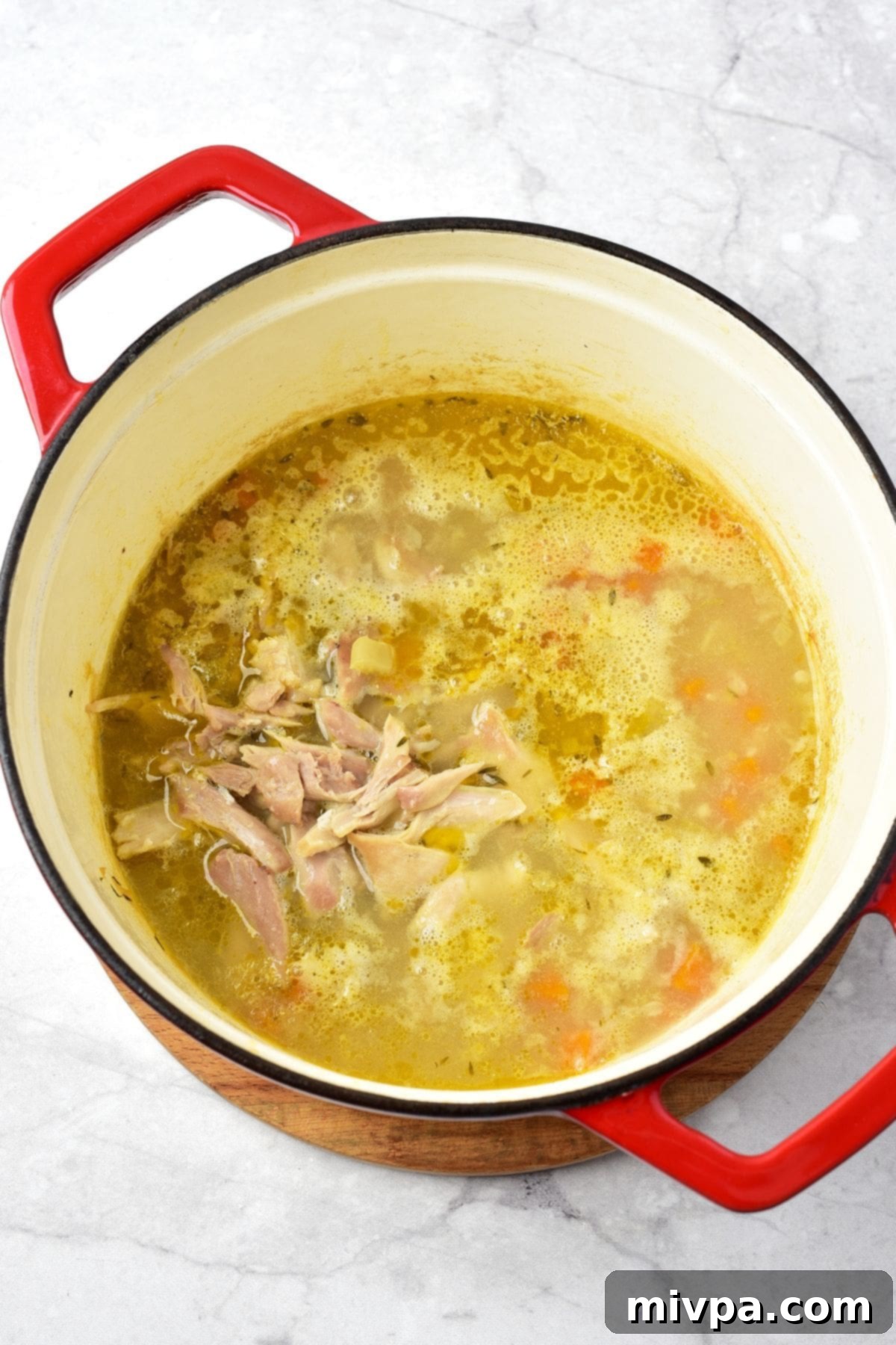 Shredded Chicken Added to Easy Chicken and Gnocchi Soup Shredded cooked chicken returned to the pot of simmering soup, stirring into the broth and vegetables.