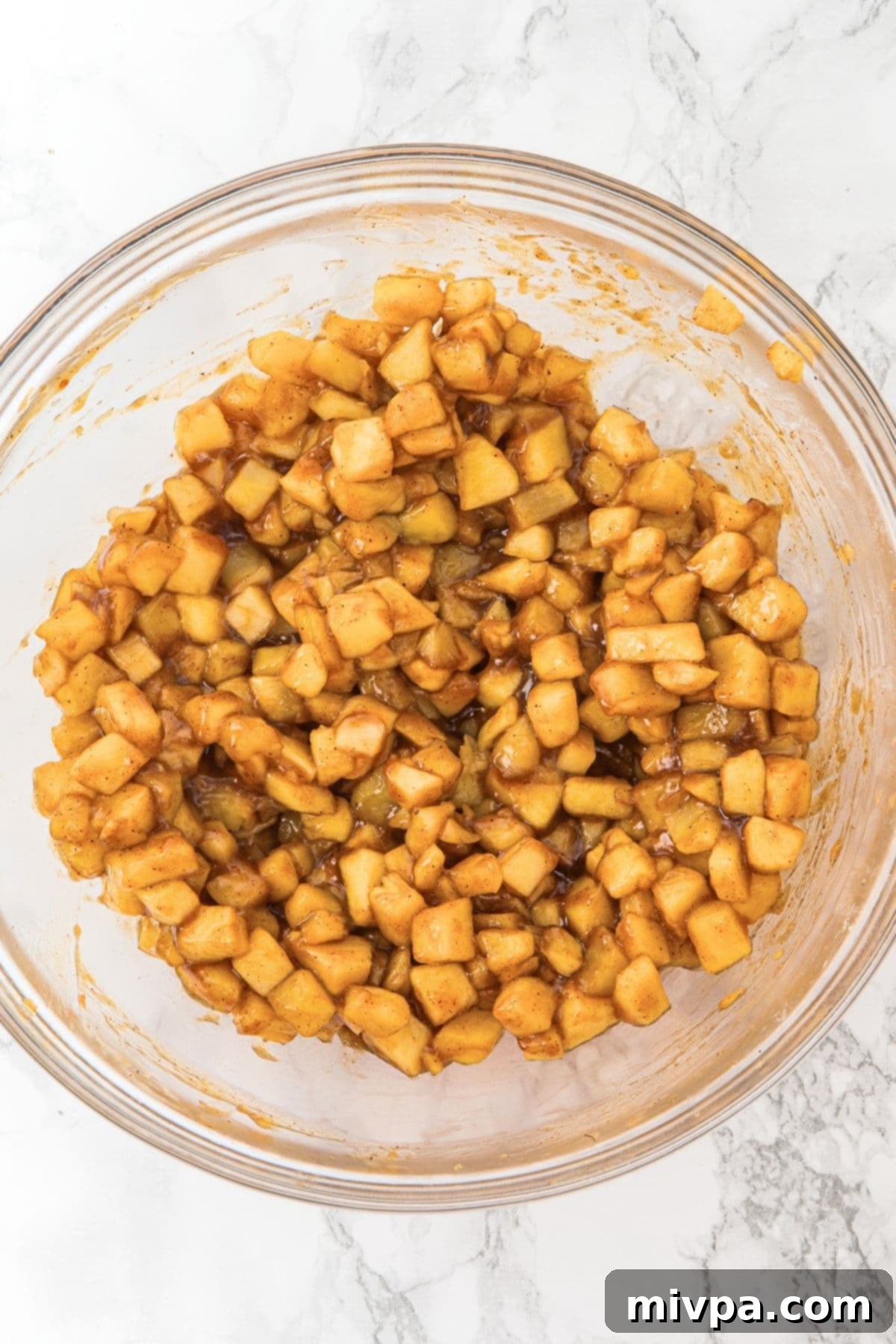 Gluten-Free Vegan Apple Bars A bowl of lightly cooked, cubed apples, now thickened with cornstarch, showing a soft but not pureed consistency.