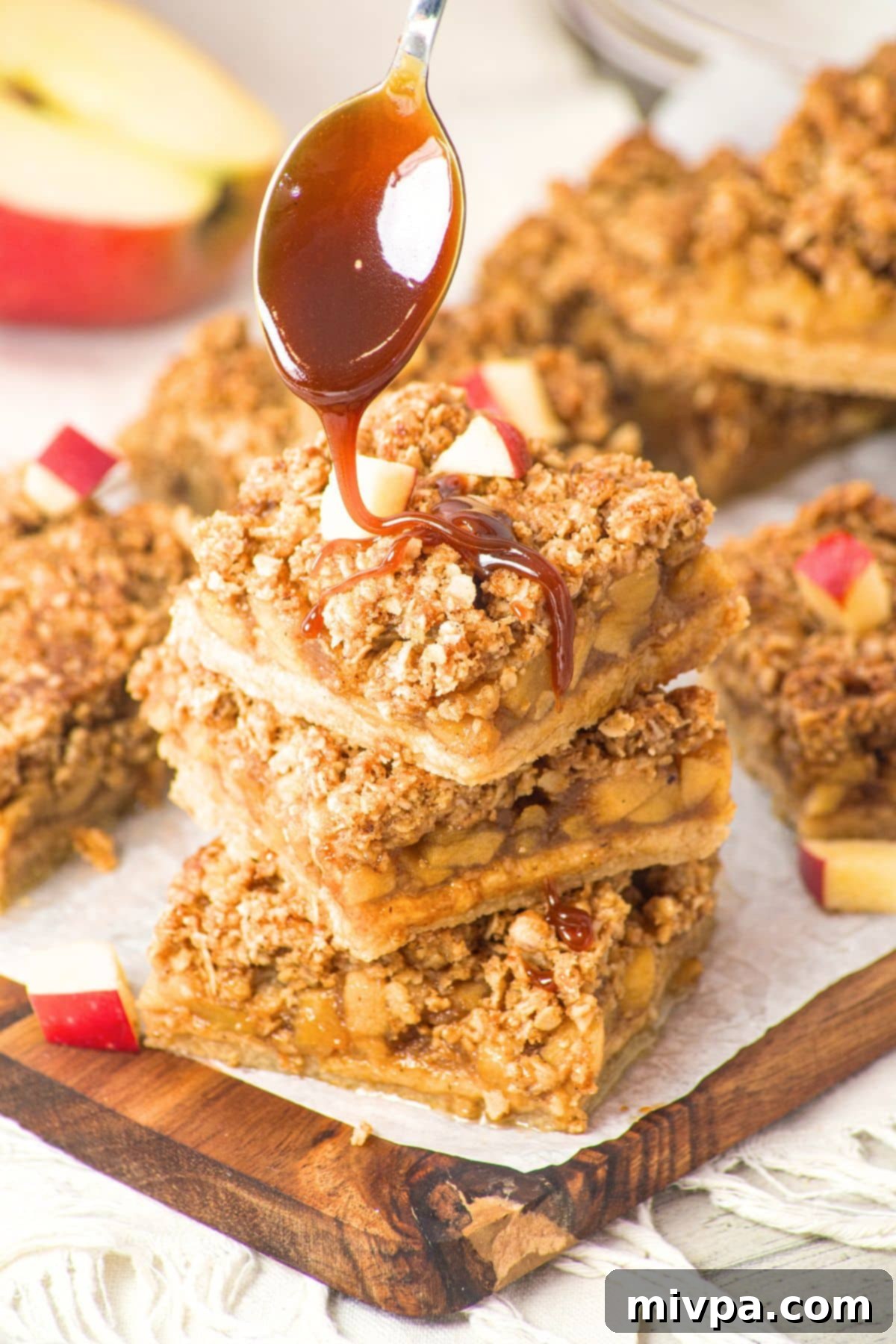 Apple Oatmeal Crumble Bars (Gluten-Free, Vegan) A close-up shot of an apple oatmeal crumble bar being drizzled generously with rich caramel sauce, highlighting its appealing texture and potential for indulgence.
