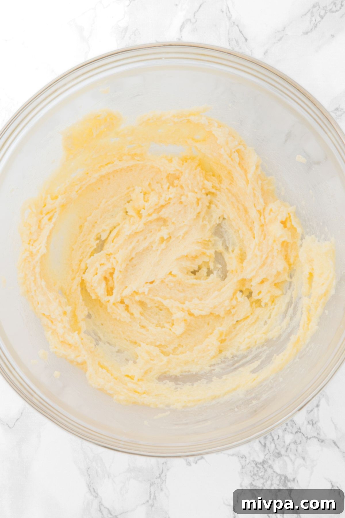 Gluten-Free Apple Oatmeal Bars A bowl containing smooth, whipped dairy-free butter, sugar, and vanilla extract, ready for mixing.