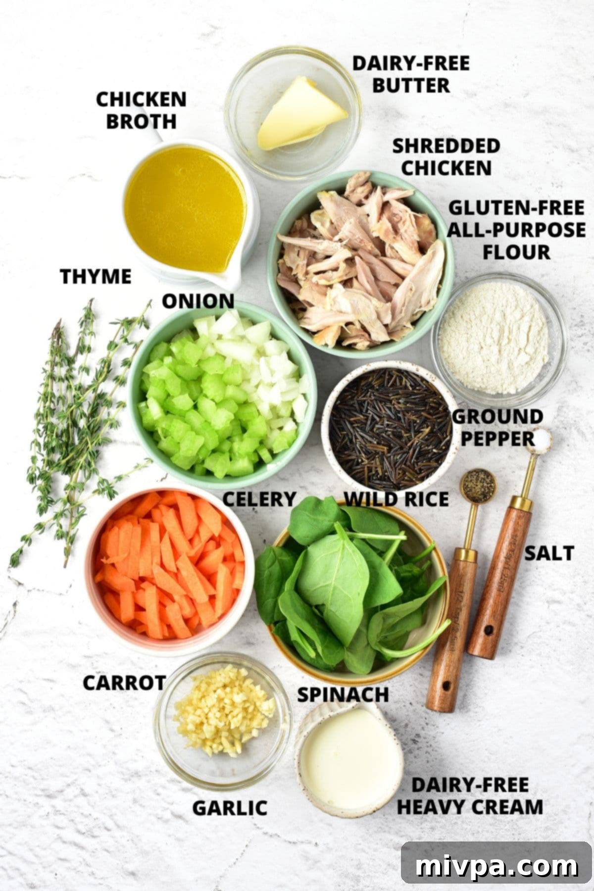 Creamy Chicken and Wild Rice Soup Recipe (Gluten-Free, Dairy-Free) Ingredients for chicken and wild rice soup recipe laid out on a marble board, including fresh vegetables, chicken, wild rice, and dairy-free alternatives.