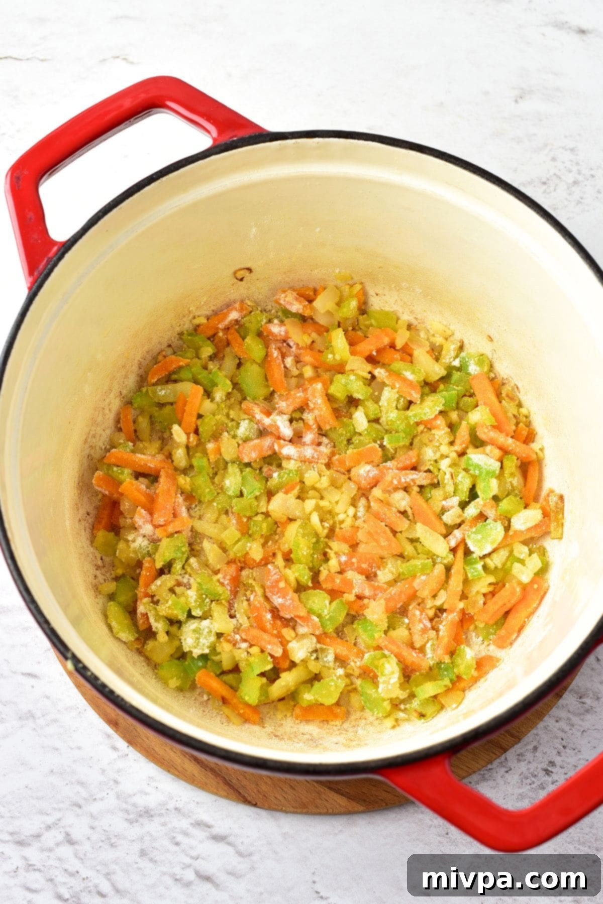 Easy Gluten-Free Chicken Wild Rice Soup Gluten-free flour sprinkled over sautéed veggies in a pot, ready to create a roux.