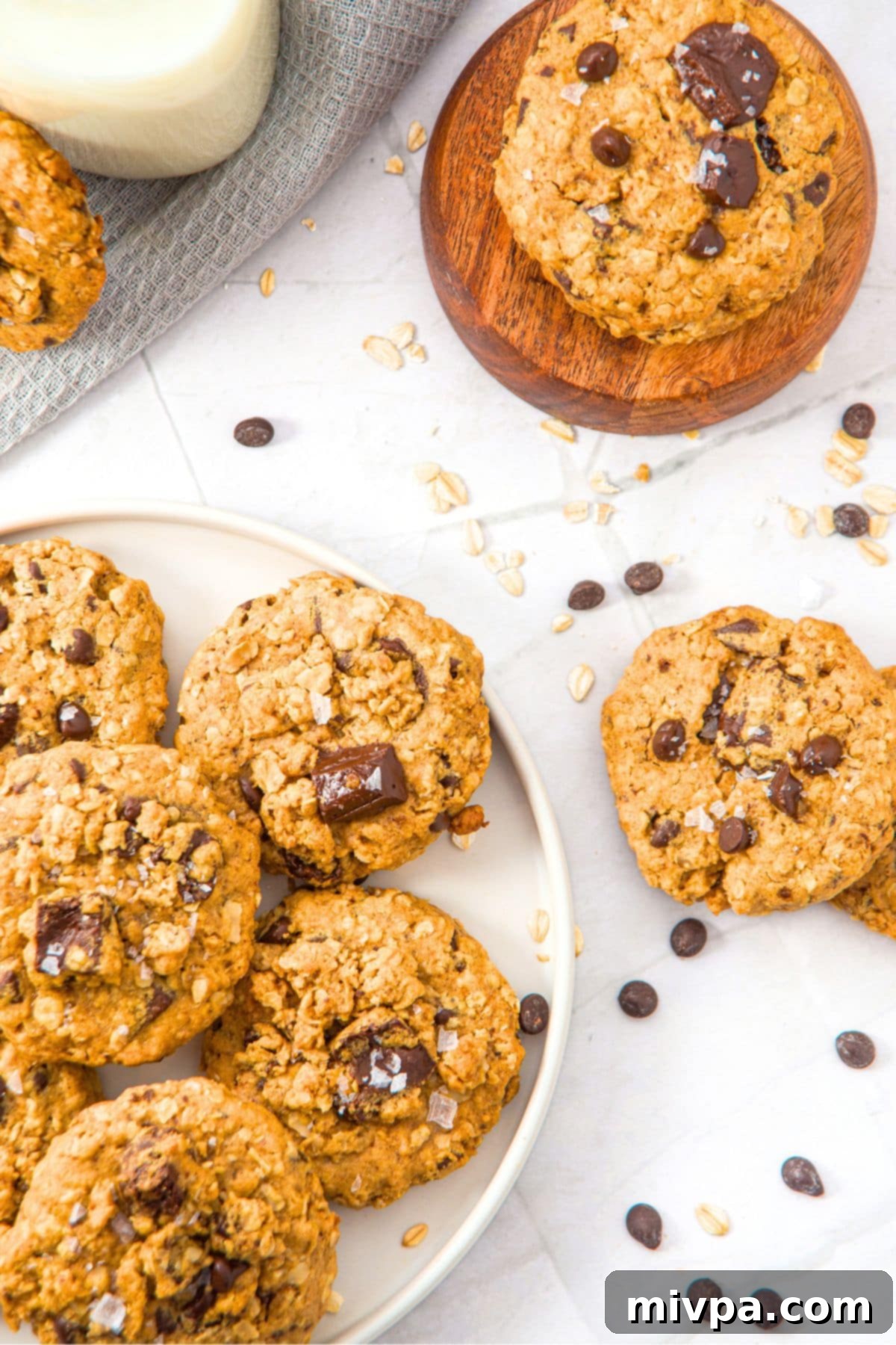 Up close view of a plate of warm, freshly baked peanut butter oatmeal cookies, some with flaky sea salt sprinkled on top.