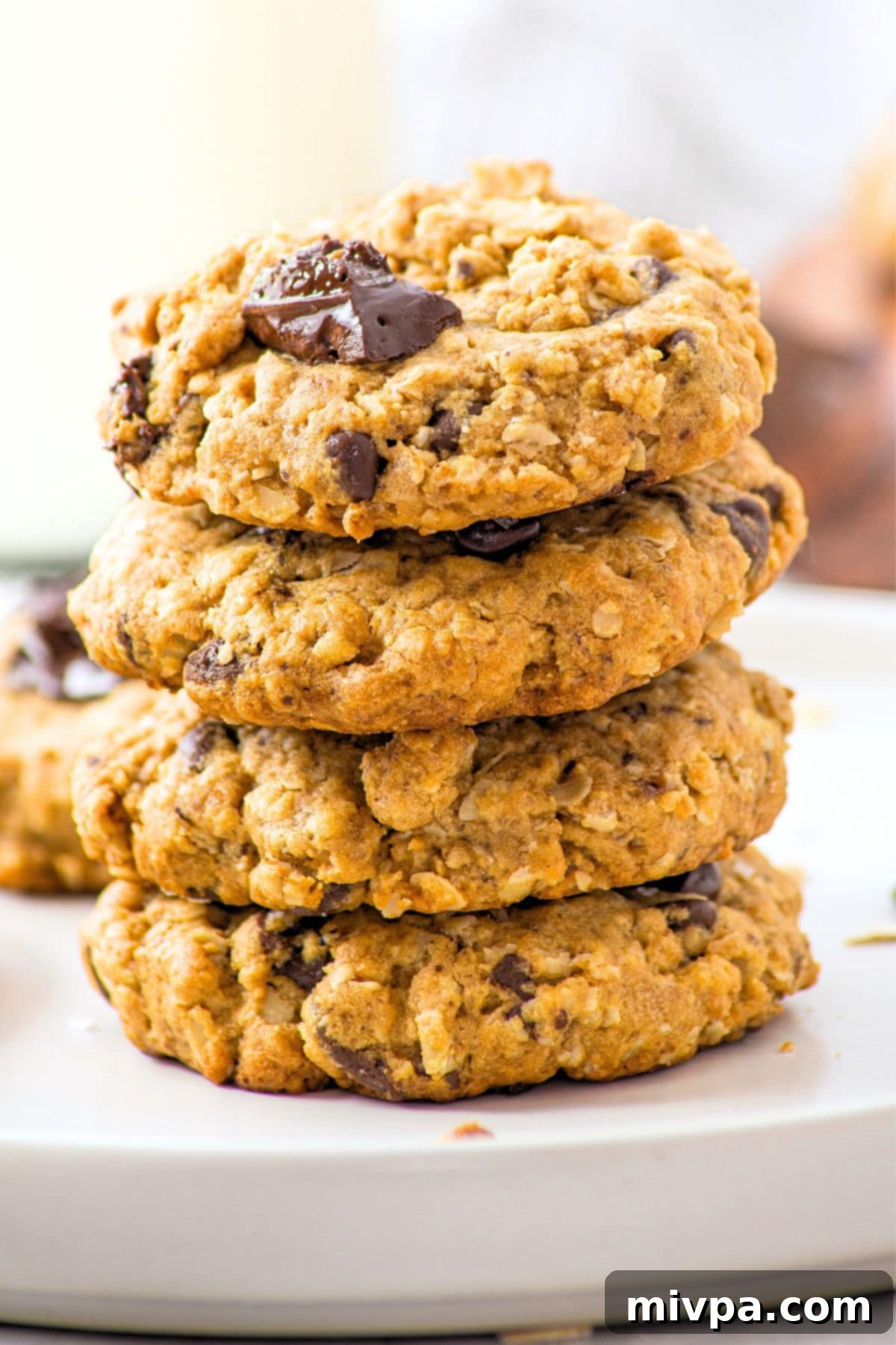 A stack of golden-brown gluten-free peanut butter oatmeal cookies, showing their chewy texture.