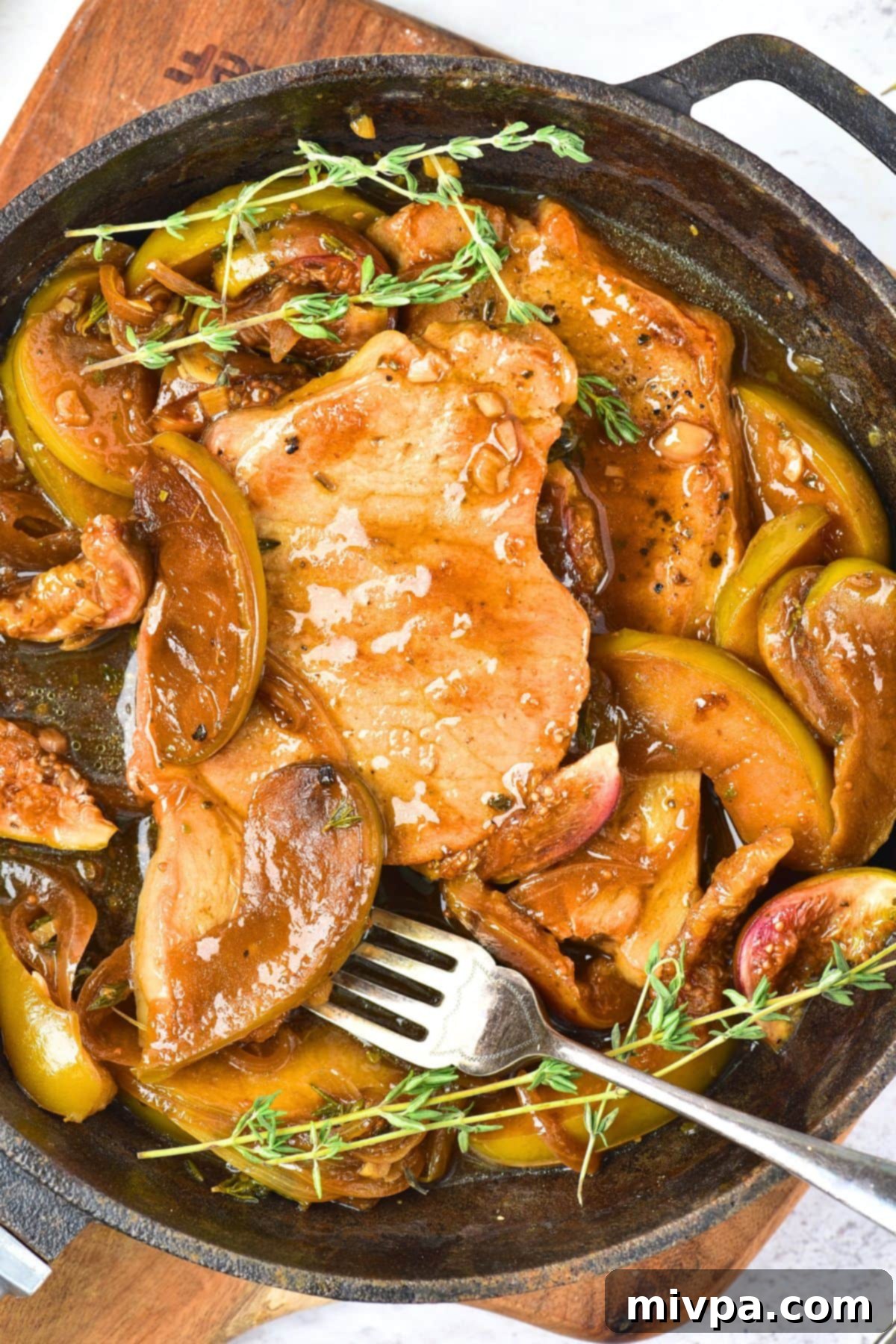 Skillet Pork Chops and Apples (Gluten-Free, Dairy-Free) Top down view of skillet pork chops and apples with herbs and figs, ready to serve