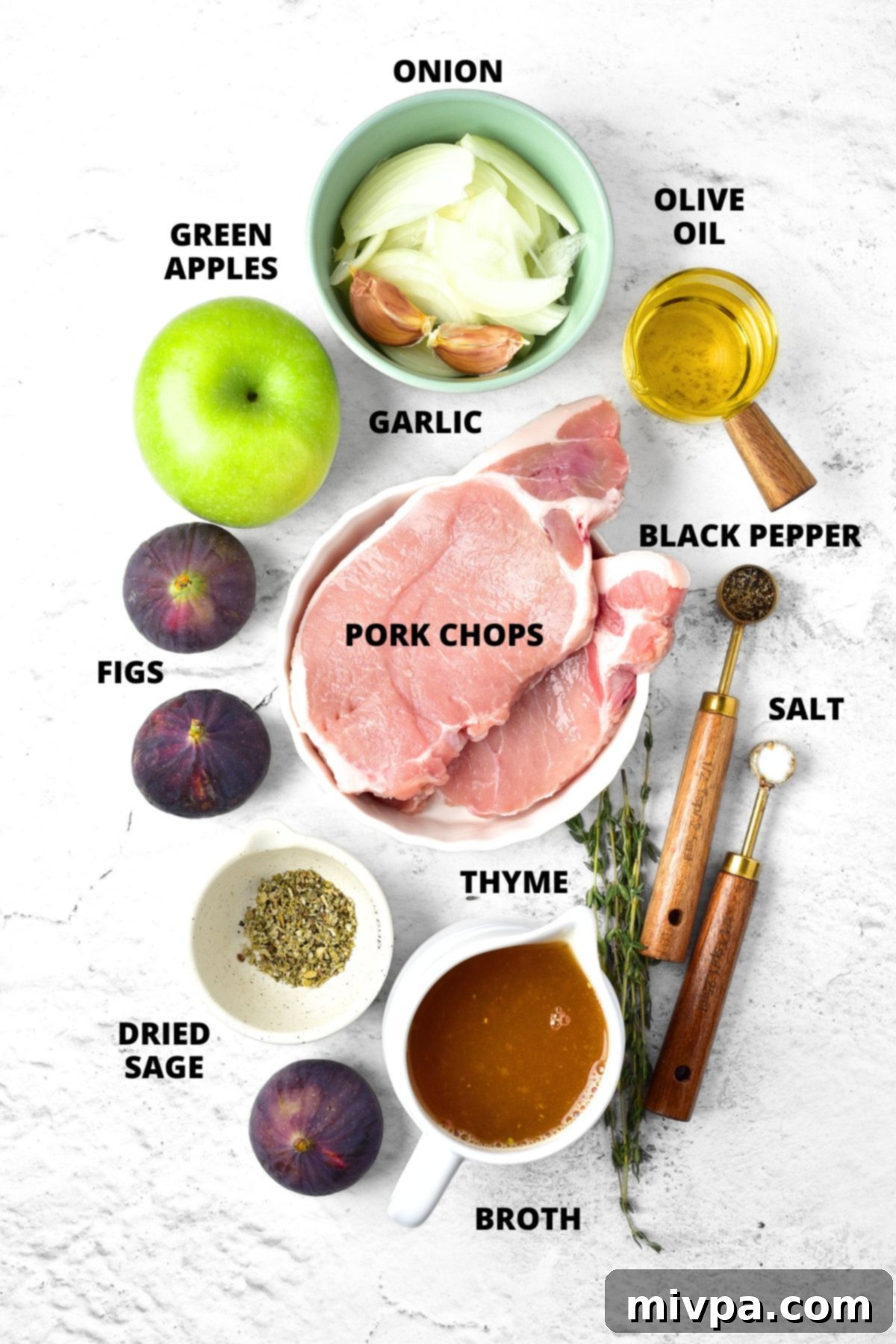 Pork Chops and Apples Recipe (Gluten-Free, Dairy-Free) All the fresh ingredients for the pork chops and apples recipe laid out on a marble board, including pork chops, apples, onions, figs, garlic, and herbs.