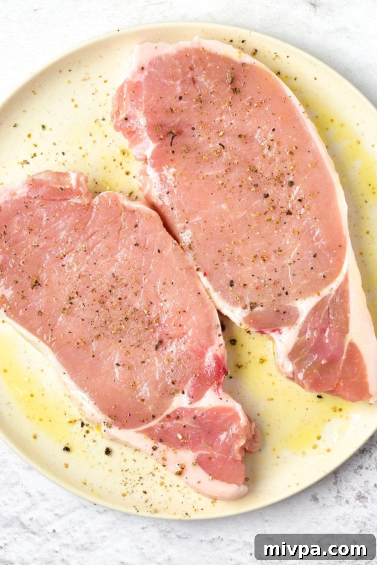 How to Make Pork Chops with Apples and Figs A plate with seasoned pork chops ready for searing