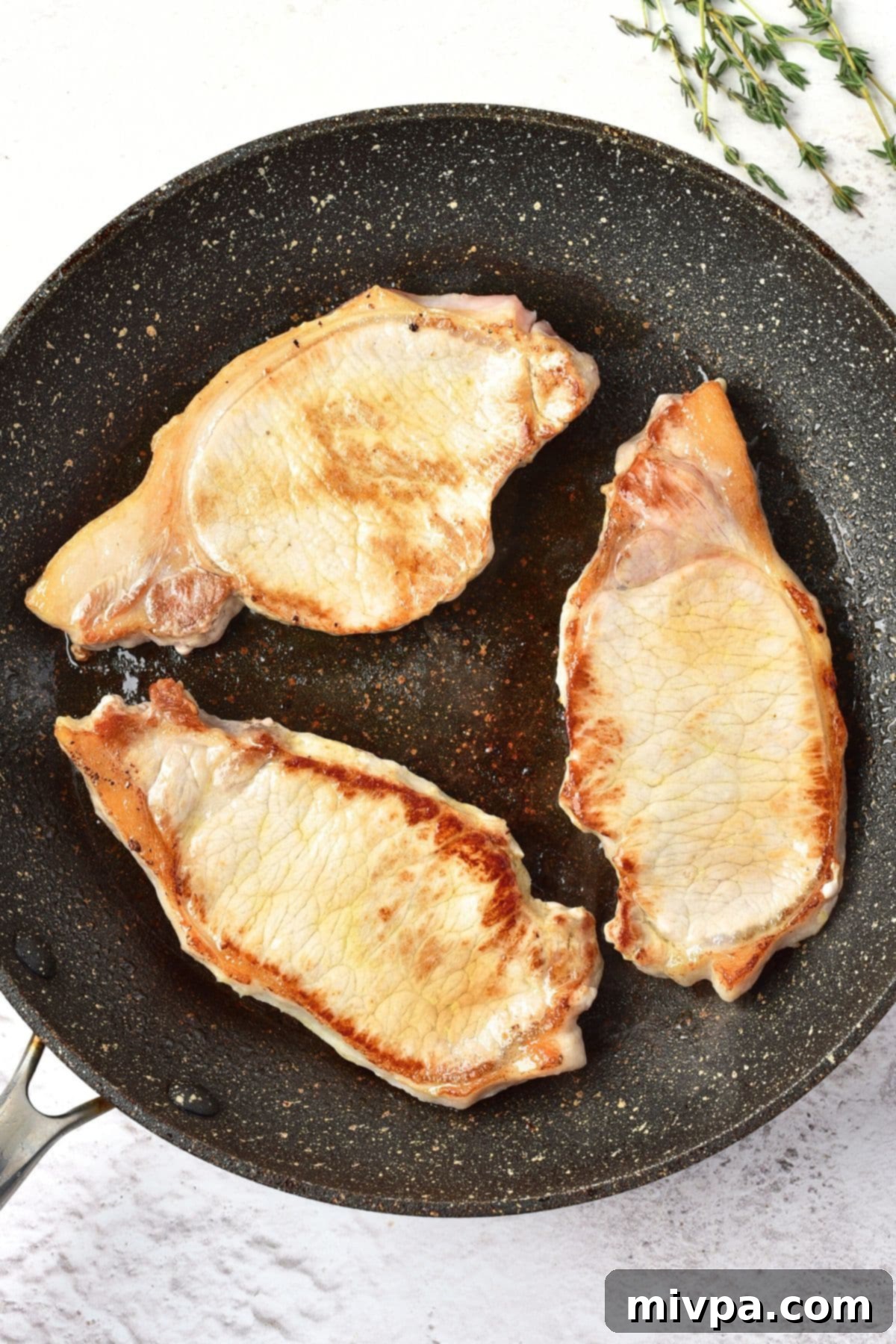 Easy Skillet Pork Chops Searing pork chops in a hot skillet until golden brown
