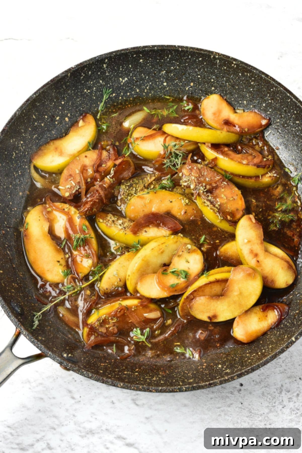 Pan-Seared Apple Pork Harvest 2 Broth simmering with apples and onions in the skillet