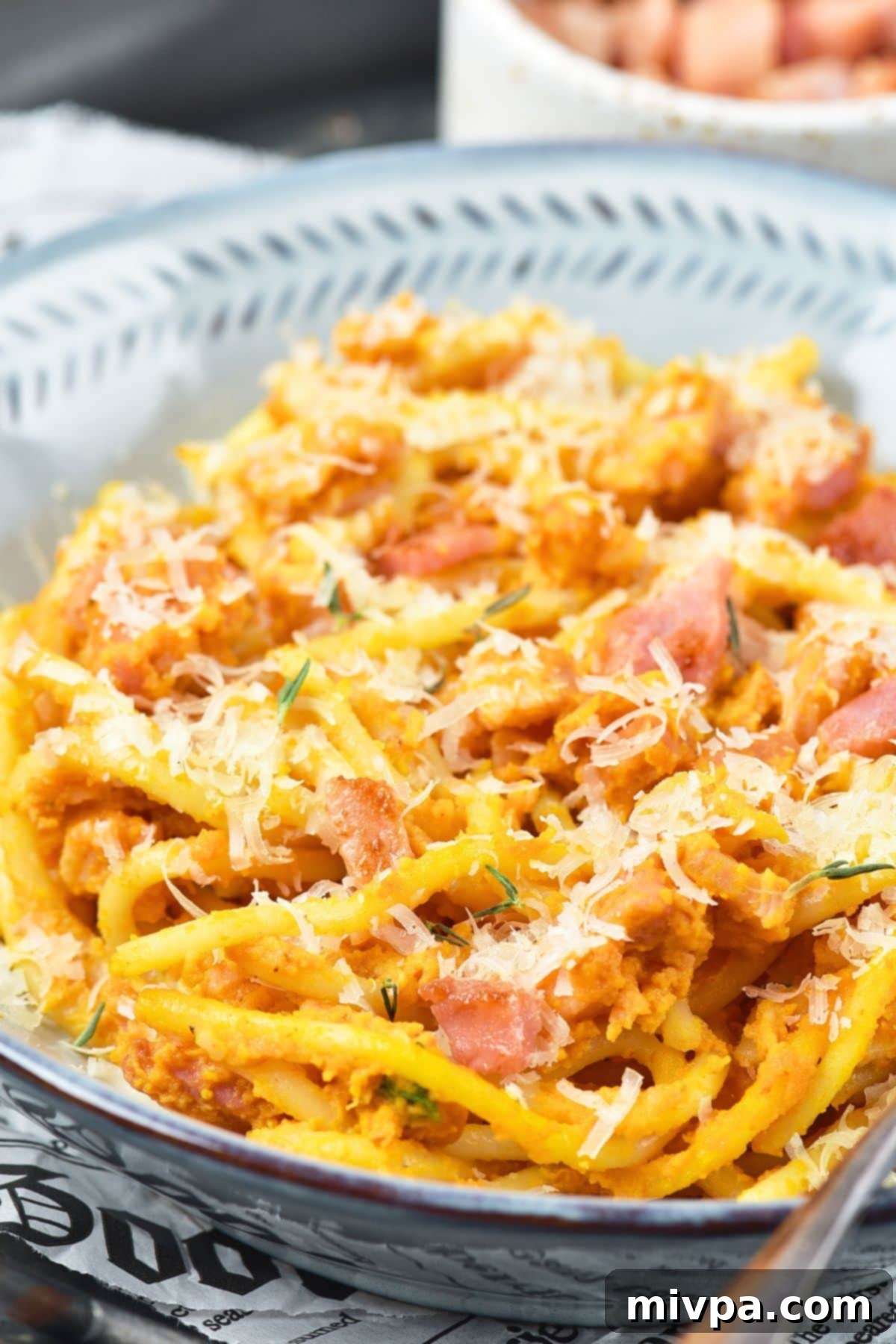 Creamy Pumpkin Carbonara (Gluten-Free, Dairy-Free Fall Pasta) Up close view of creamy pumpkin carbonara topped with shredded dairy-free cheese and fresh herbs