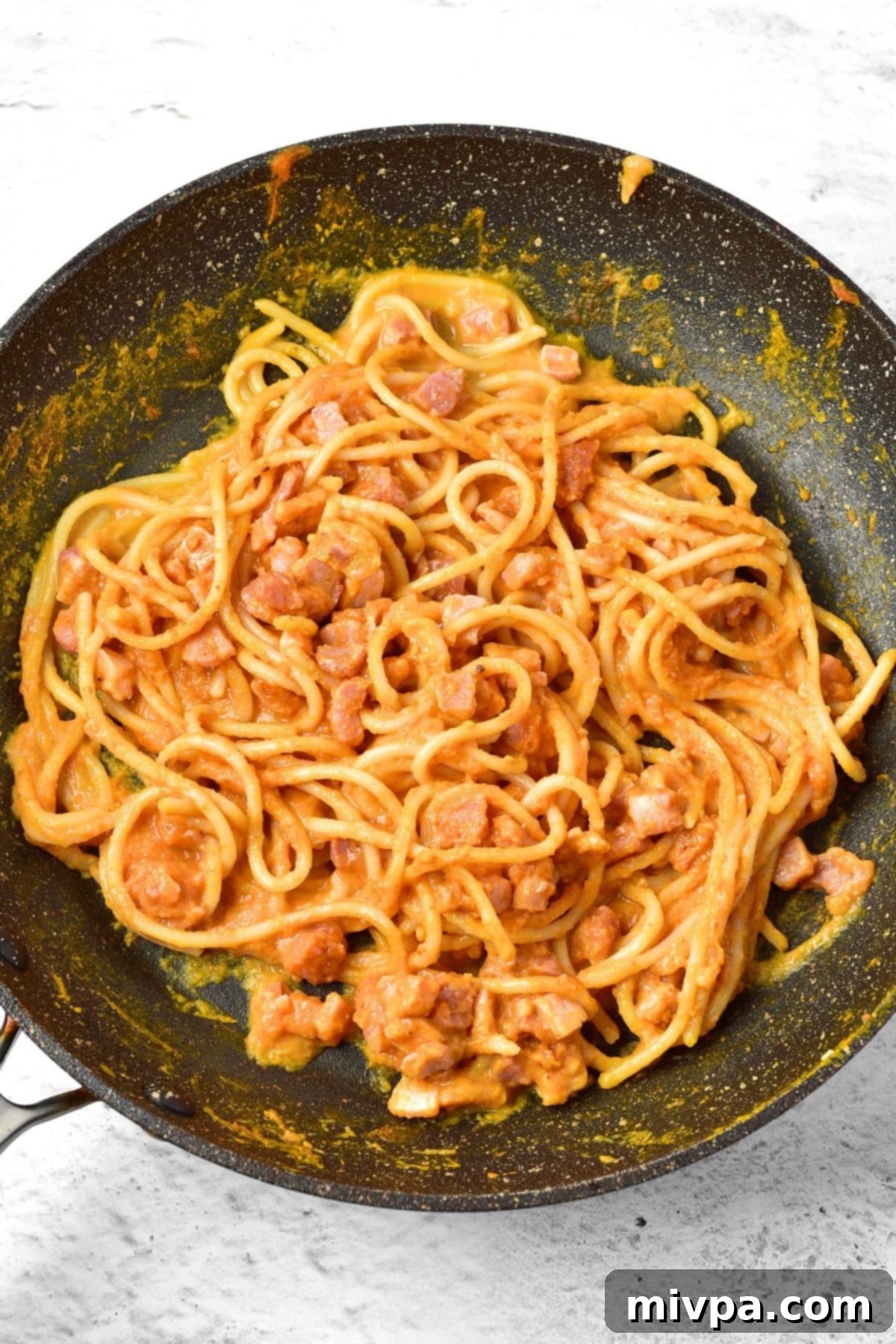 Pumpkin Carbonara (Gluten-Free, Dairy-Free) Final Toss Pumpkin carbonara pasta in a skillet with crispy pancetta and garlic mixed in.