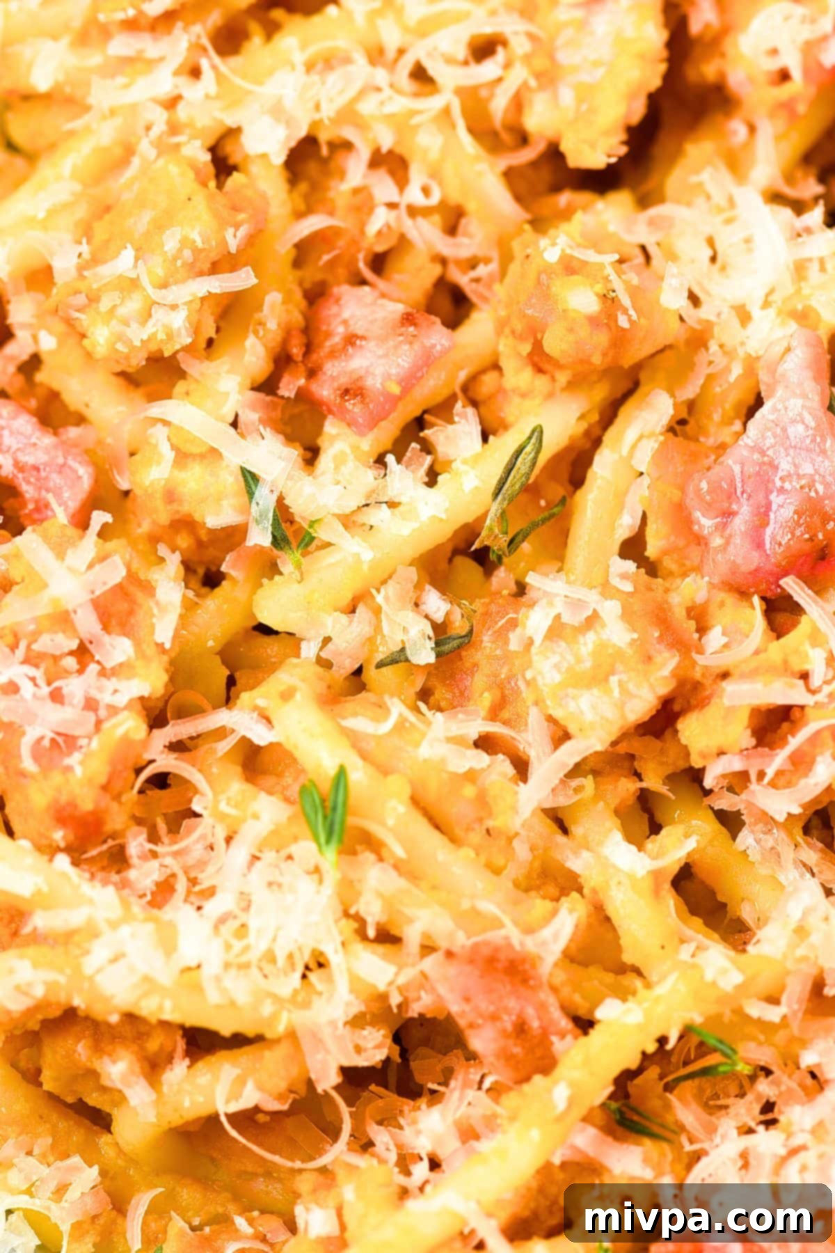 How to Make Easy Pumpkin Carbonara at Home Up close view of gluten-free spaghetti tossed with dairy-free cheese and crispy pancetta