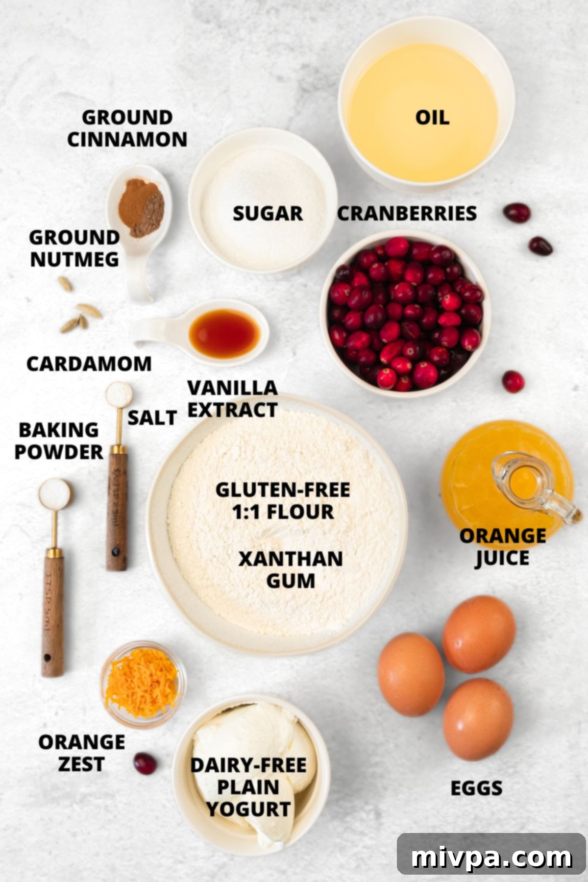 Gluten-Free Cranberry Orange Muffins Recipe (Dairy-Free) Ingredients for gluten-free cranberry orange muffins recipe beautifully laid out on a white cutting board.