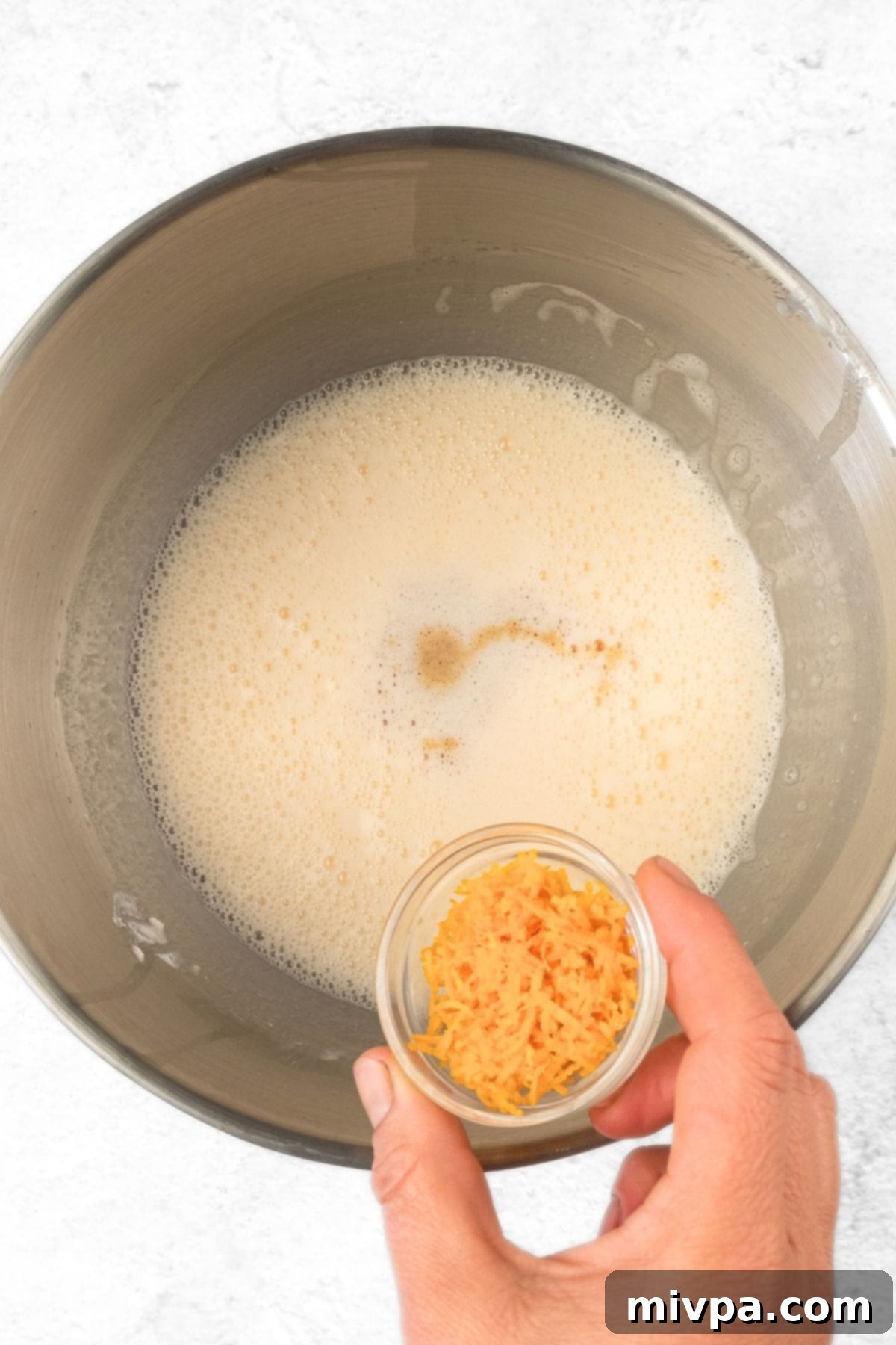 Gluten-Free Cranberry Orange Muffins (Dairy-Free) Adding fresh orange zest to the pale yellow muffin batter.