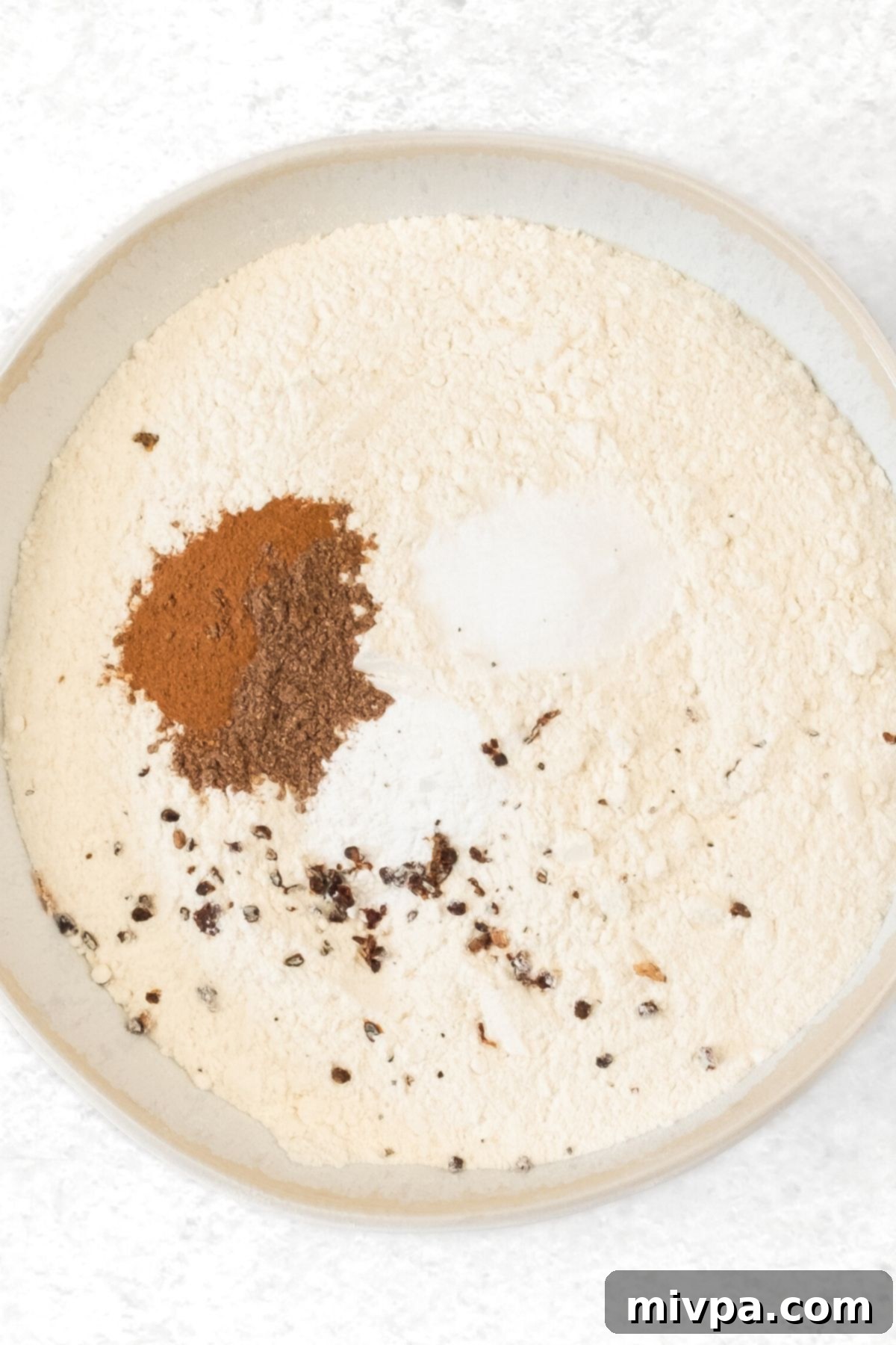 Gluten Dairy-Free Cranberry Orange Muffins Dry ingredients for muffins mixed in a white mixing bowl.