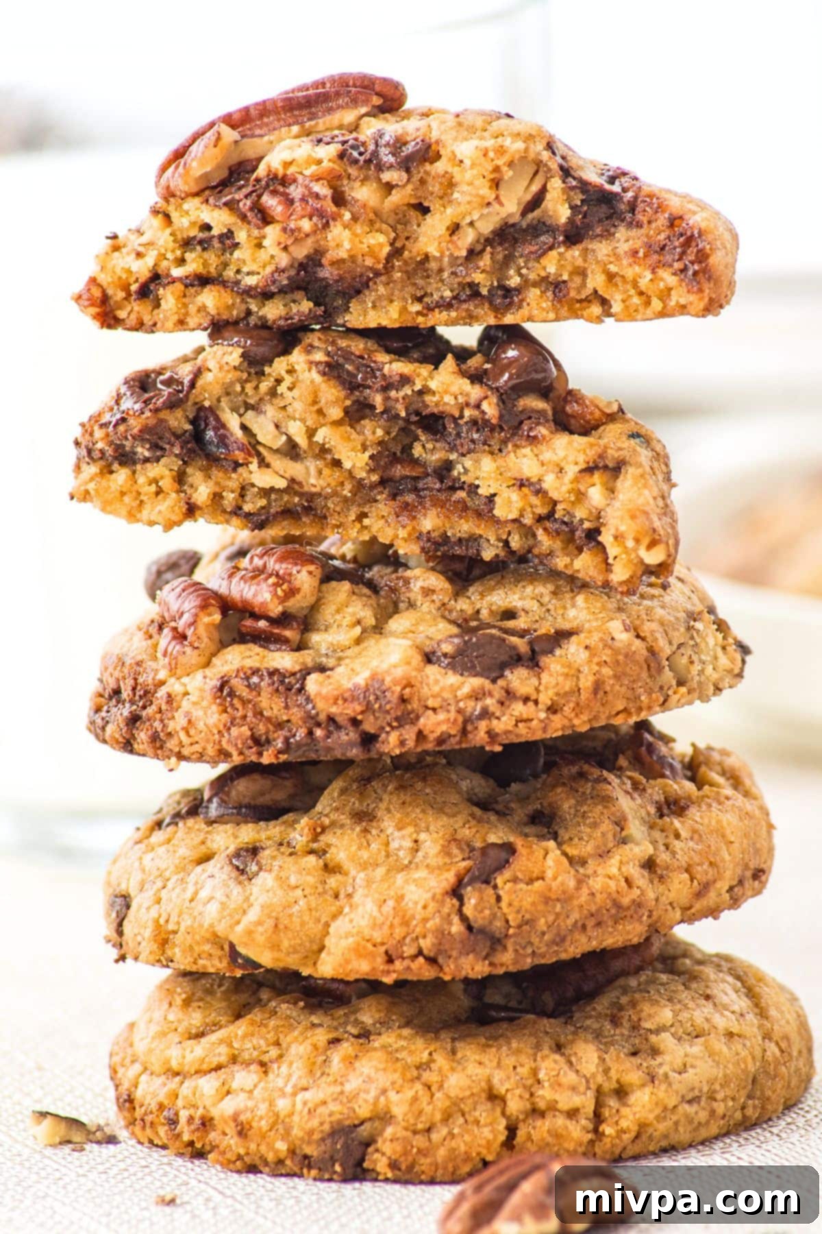 Pecan Chocolate Chip Cookies (Gluten-Free) A stack of golden-brown pecan chocolate chip cookies, showcasing their texture.