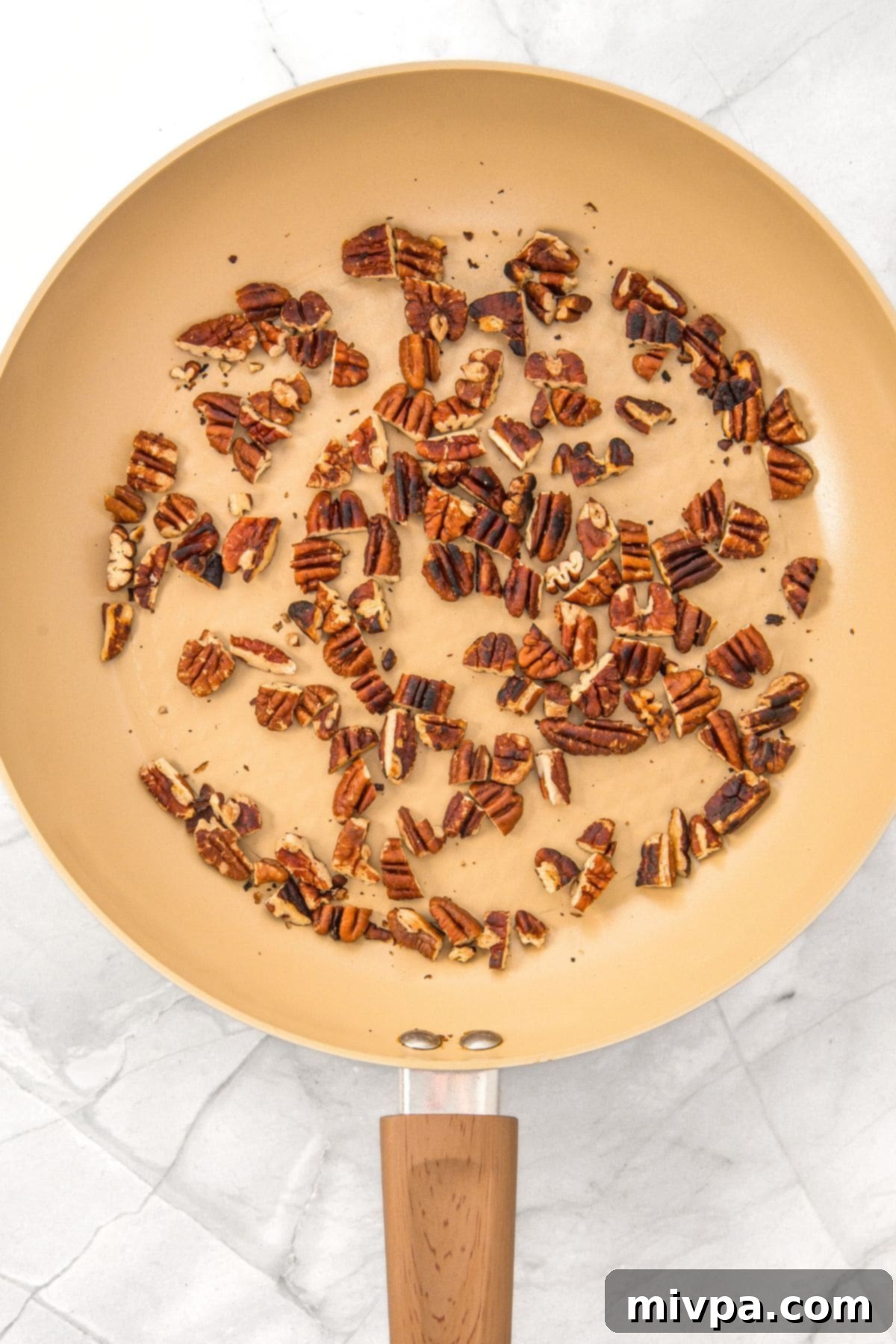 Brown Butter Pecan Chocolate Chip Cookie Recipe (Gluten-Free) Coarsely chopped pecans toasting in a skillet, turning golden brown.