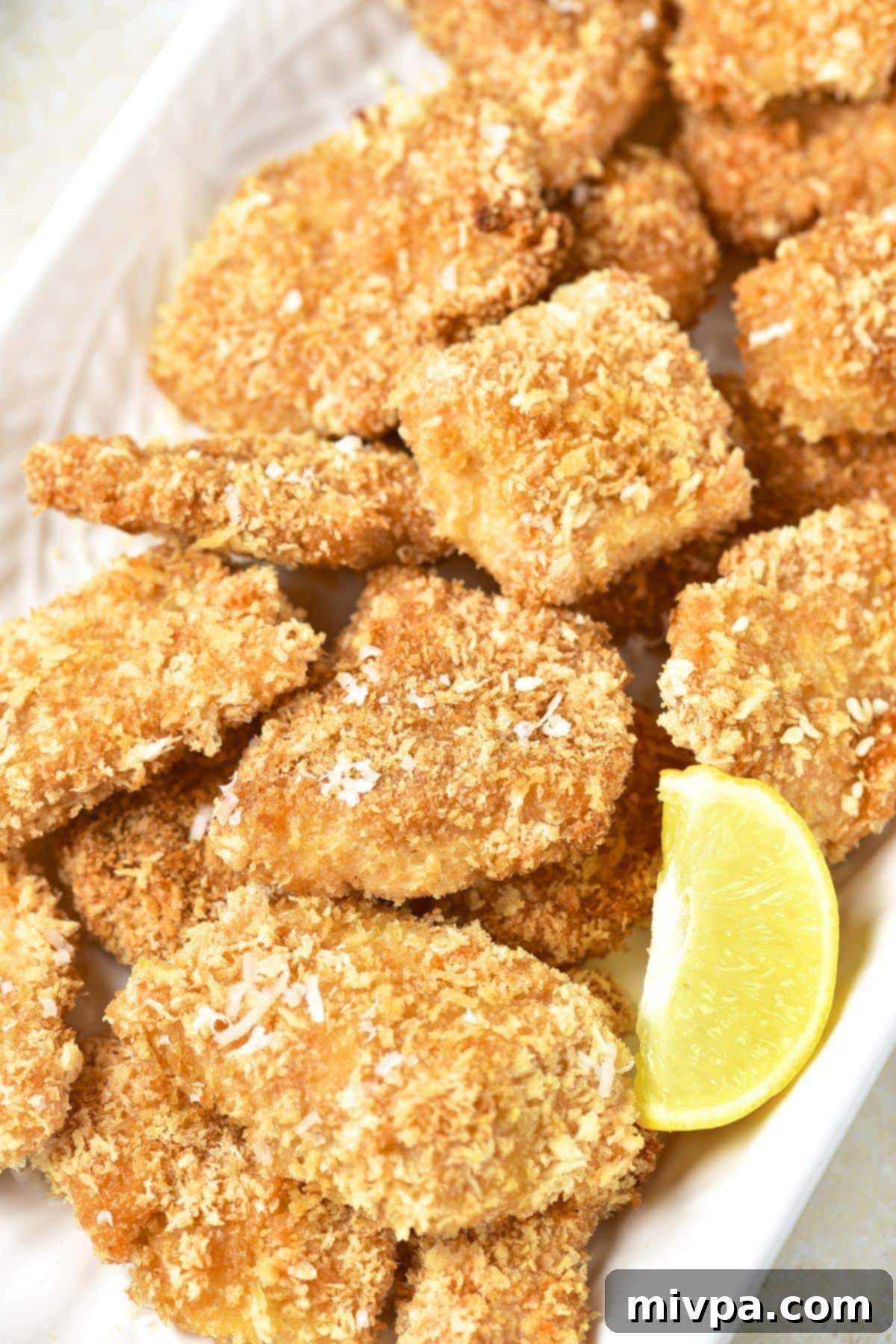 Homemade Turkey Nuggets (Gluten-Free, Dairy-Free) Homemade turkey nuggets on a white plate, garnished with fresh herbs.