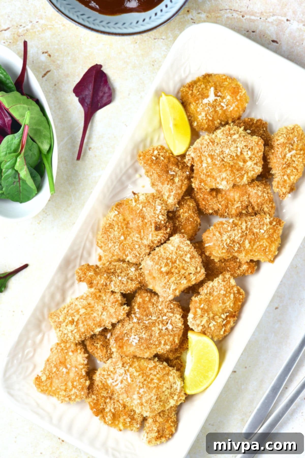 Turkey Nuggets Recipe (Gluten-Free, Dairy-Free) Top down view of a plate of turkey nuggets and lemon wedges.