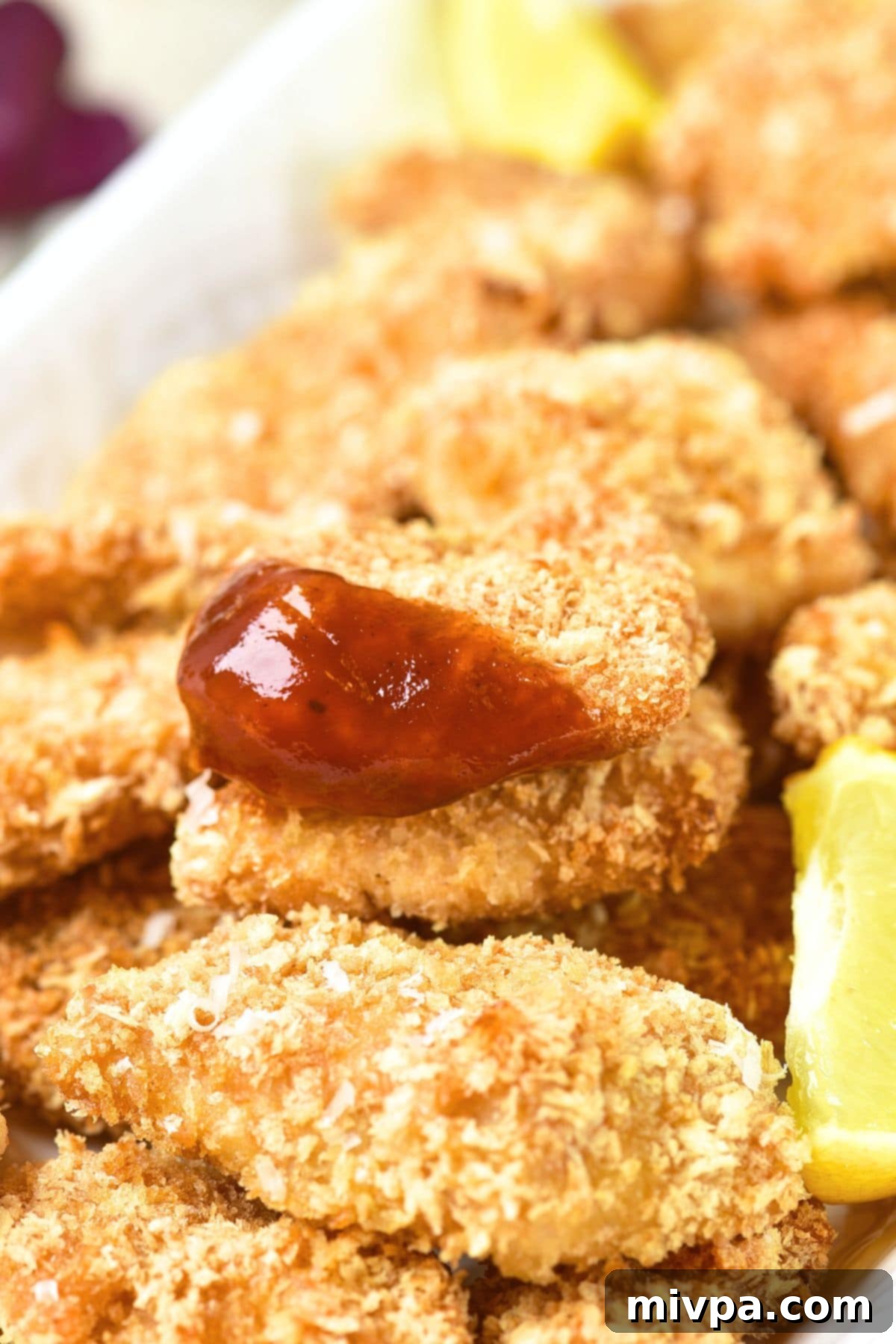Gluten-Free Turkey Nuggets Recipe Up close view of gluten-free turkey nuggets dipped in ketchup.
