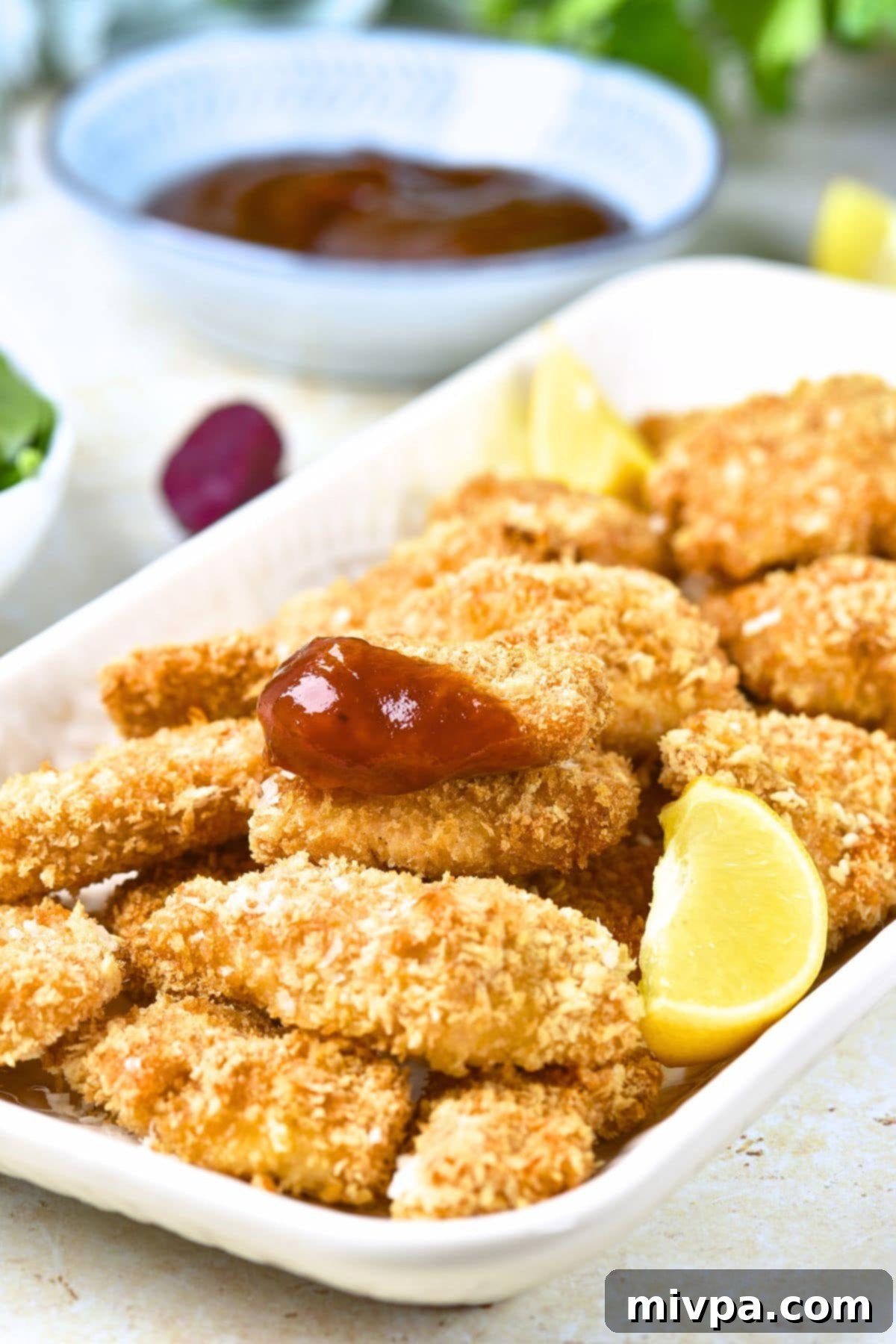 Baked Turkey Nuggets (Gluten-Free, Dairy-Free) A plate of baked turkey nuggets with lemon wedges.
