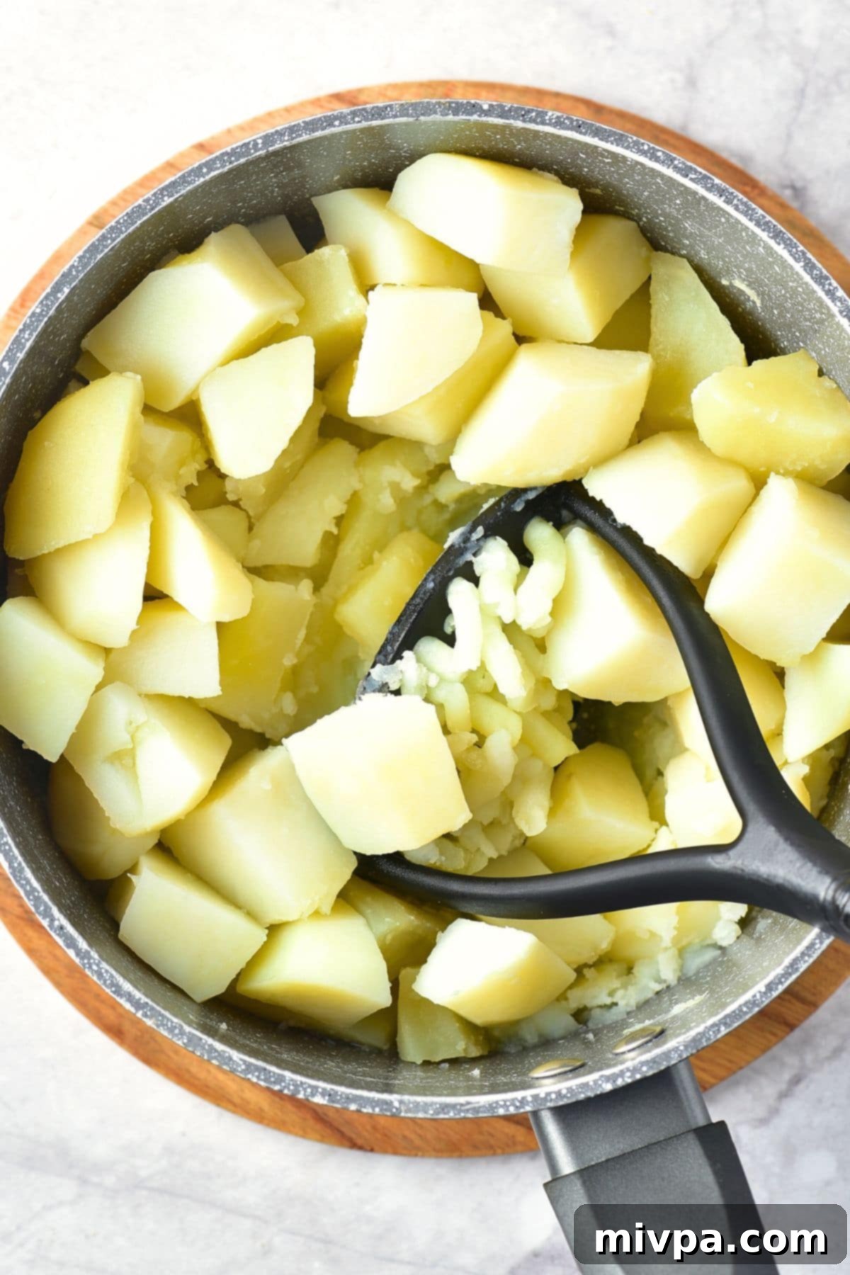 Creamy Garlic Potato Mash Mashing potatoes with a potato ricer