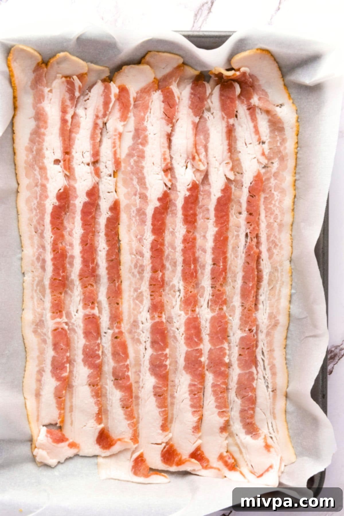 How to Make Loaded Tater Tots (Gluten-Free) Bacon slices on parchment-lined baking sheet